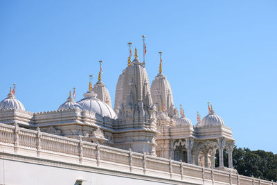 Golden gate of temple against clear blue sky