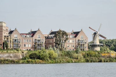 Retro style housing with windmill seen from the river