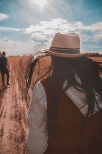 Rear view of woman in hat against sky