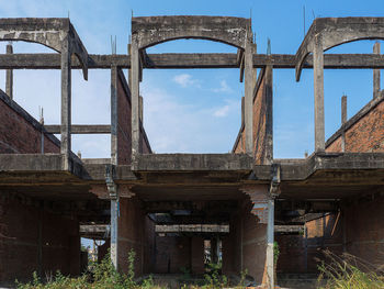 Low angle view of abandoned bridge against sky