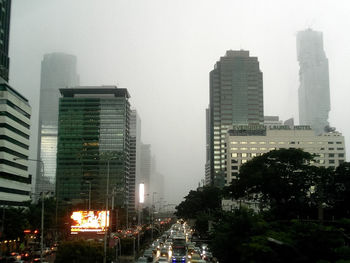 Buildings in city against cloudy sky