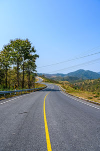 Road by trees against sky