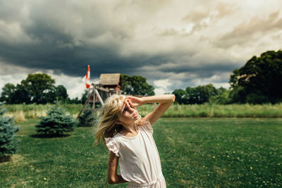 Full length of woman standing on field against sky