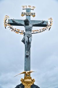 Low angle view of cross statue against sky