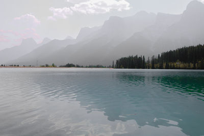 Scenic view of lake by mountains against sky