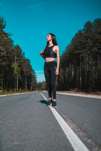 Full length of woman standing on road in city