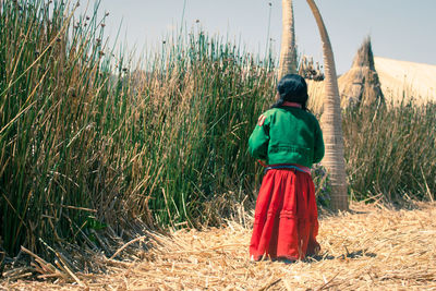 Rear view of woman standing on field