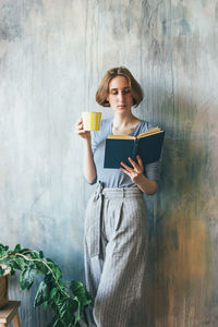 Full length of a young woman drinking coffee cup