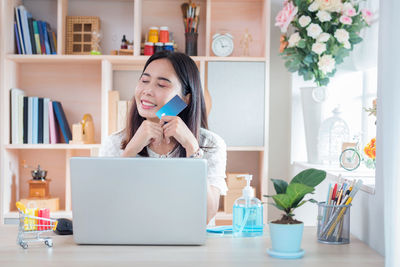 Young woman using smart phone at home