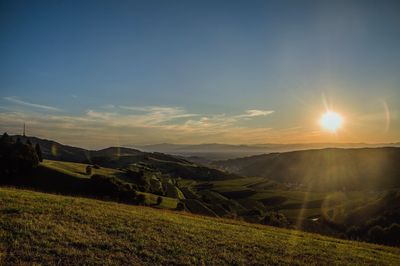 Scenic view of agricultural field against sky during sunset