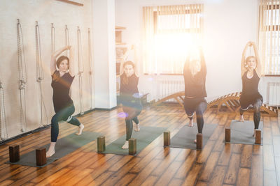 Woman with arms raised on hardwood floor