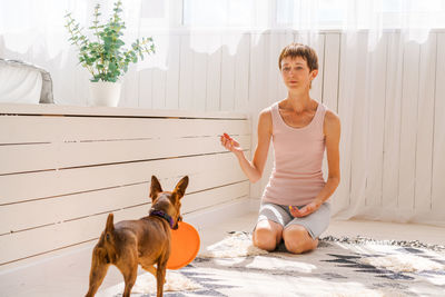 Woman practicing exercising with dog to enjoying and relaxing with yoga. spend