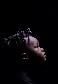 Close-up portrait of man against black background