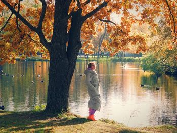 Full length of woman standing by lake