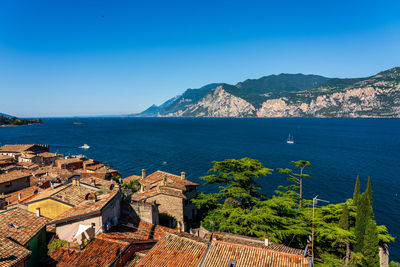 High angle view of townscape by sea against sky