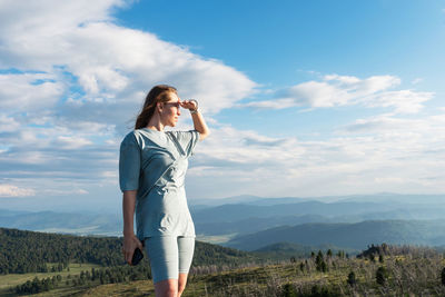 Full length of woman standing on land against sky