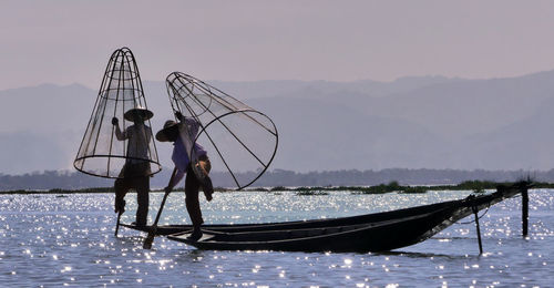 Man standing on fishing net against sky
