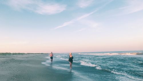 People on beach against sky