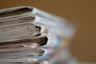 Close-up of stacked newspapers against brown background