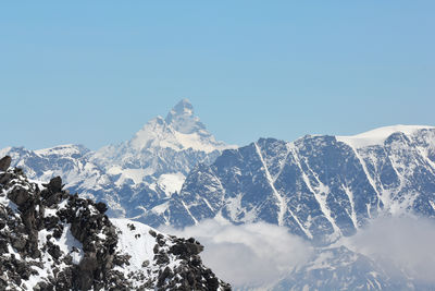 Scenic view of snowcapped mountains against clear blue sky