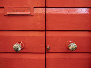 Red painted wood door with a mail box
