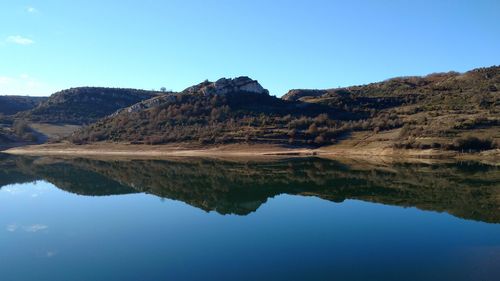 Reflection of mountains in lake against blue sky