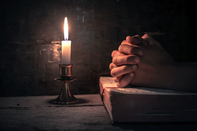 Close-up of hand holding candles on table