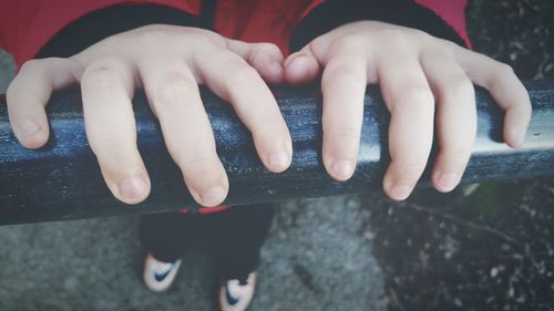 Close-up of boy hands on railing