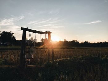 Built structure on field against sky during sunset