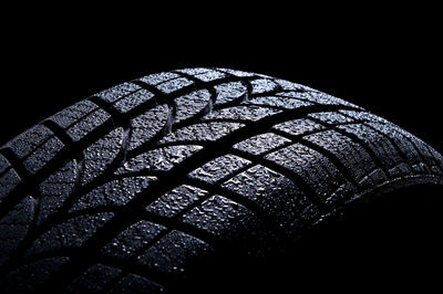 Close-up of wet tire against black background