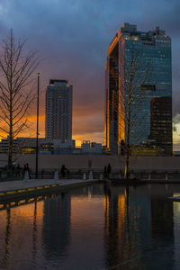 Reflection of buildings in city at sunset