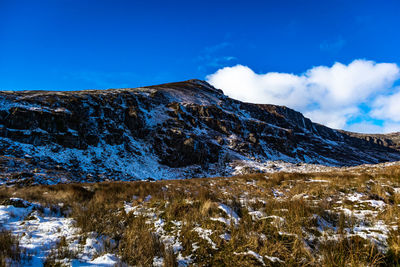 Scenic view of snowcapped mountains against blue sky