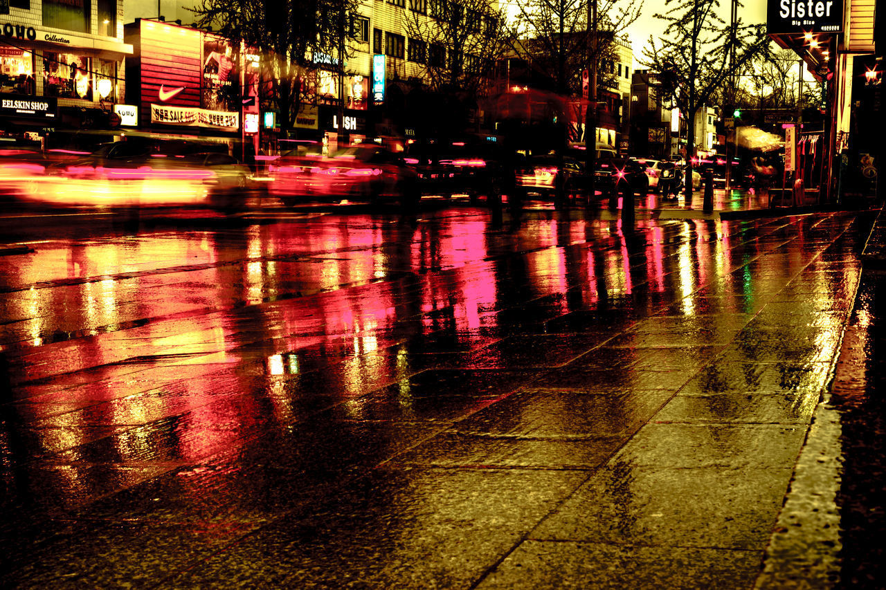 REFLECTION OF ILLUMINATED ROAD IN RAIN