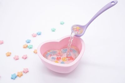 High angle view of candies in bowl against white background