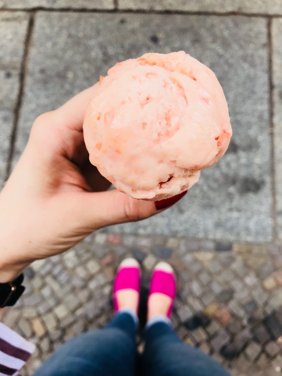 LOW SECTION OF WOMAN HOLDING ICE CREAM OUTDOORS