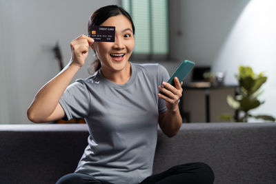 Young woman using mobile phone at home
