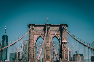 Low angle view of suspension bridge against blue sky