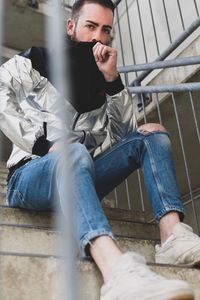 Low angle portrait of young man sitting on steps