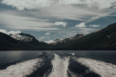Scenic view of lake by mountains against sky