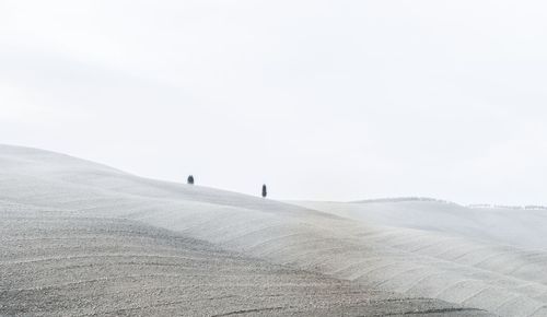 Man walking on landscape against sky