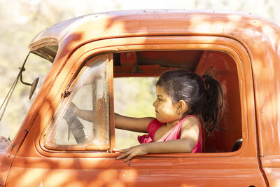 Portrait of girl sitting in window