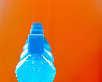 Close-up of blue bottle against orange background