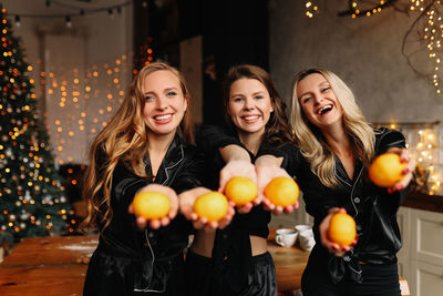 Happy women friends celebrate the christmas holiday at a party in the cozy kitchen of the house