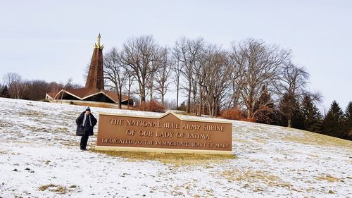 Text on snow covered field against sky