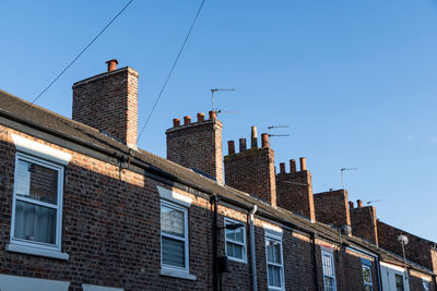 Low angle view of buildings against clear blue sky