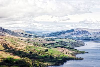 Scenic view of river amidst mountains against sky