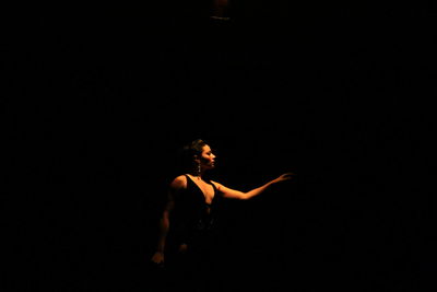 Woman dancing against black background