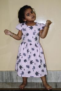 Portrait of cute girl standing against wall