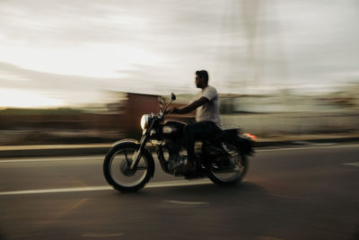 Man riding motor scooter on road