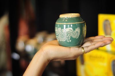 Close-up of hand holding earthenware